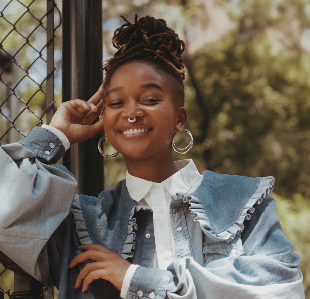 woman smiling wearing a ganni denim jacket