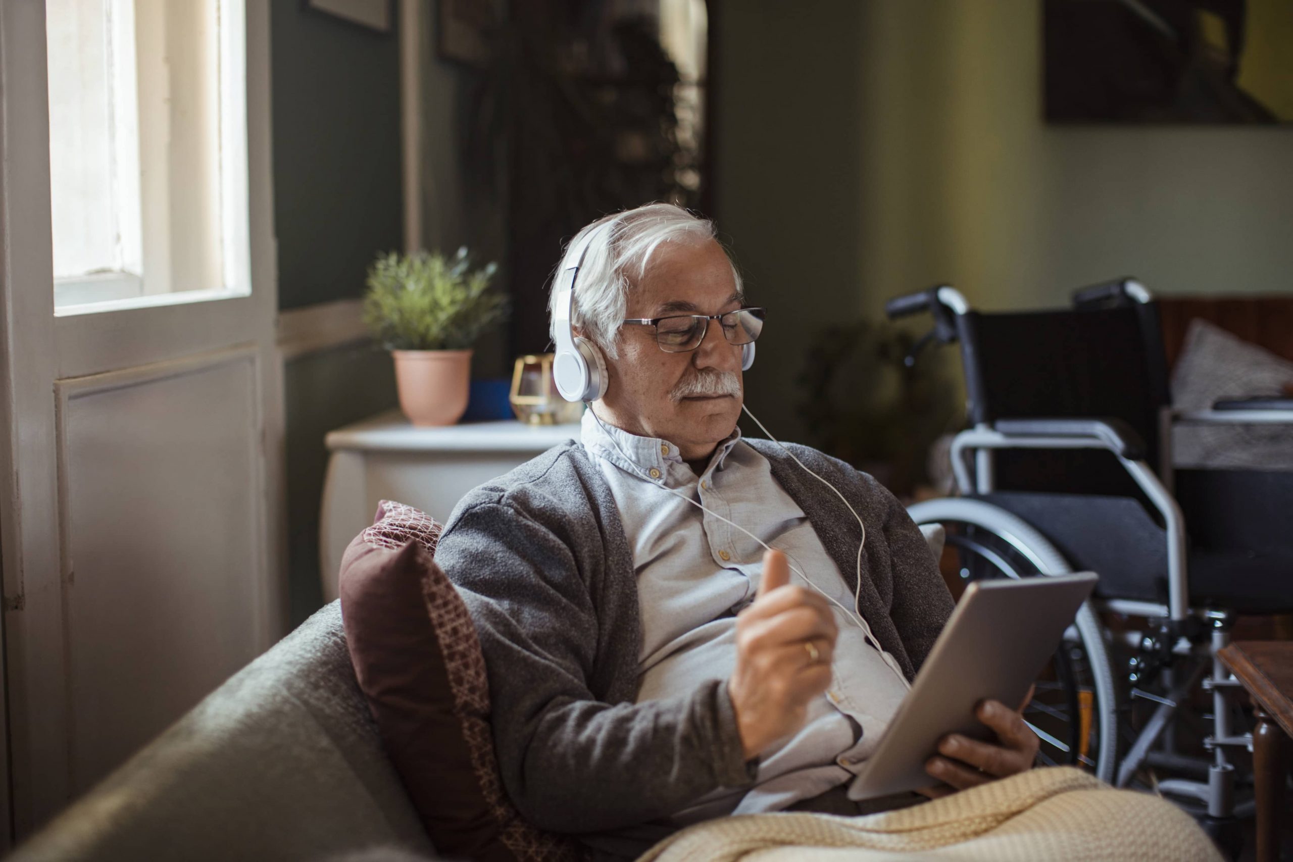 grandpa on iPad with headphones on