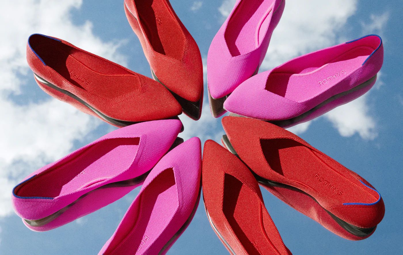 Bright pink and red pointed flats arranged in a circular pattern against a blue sky.