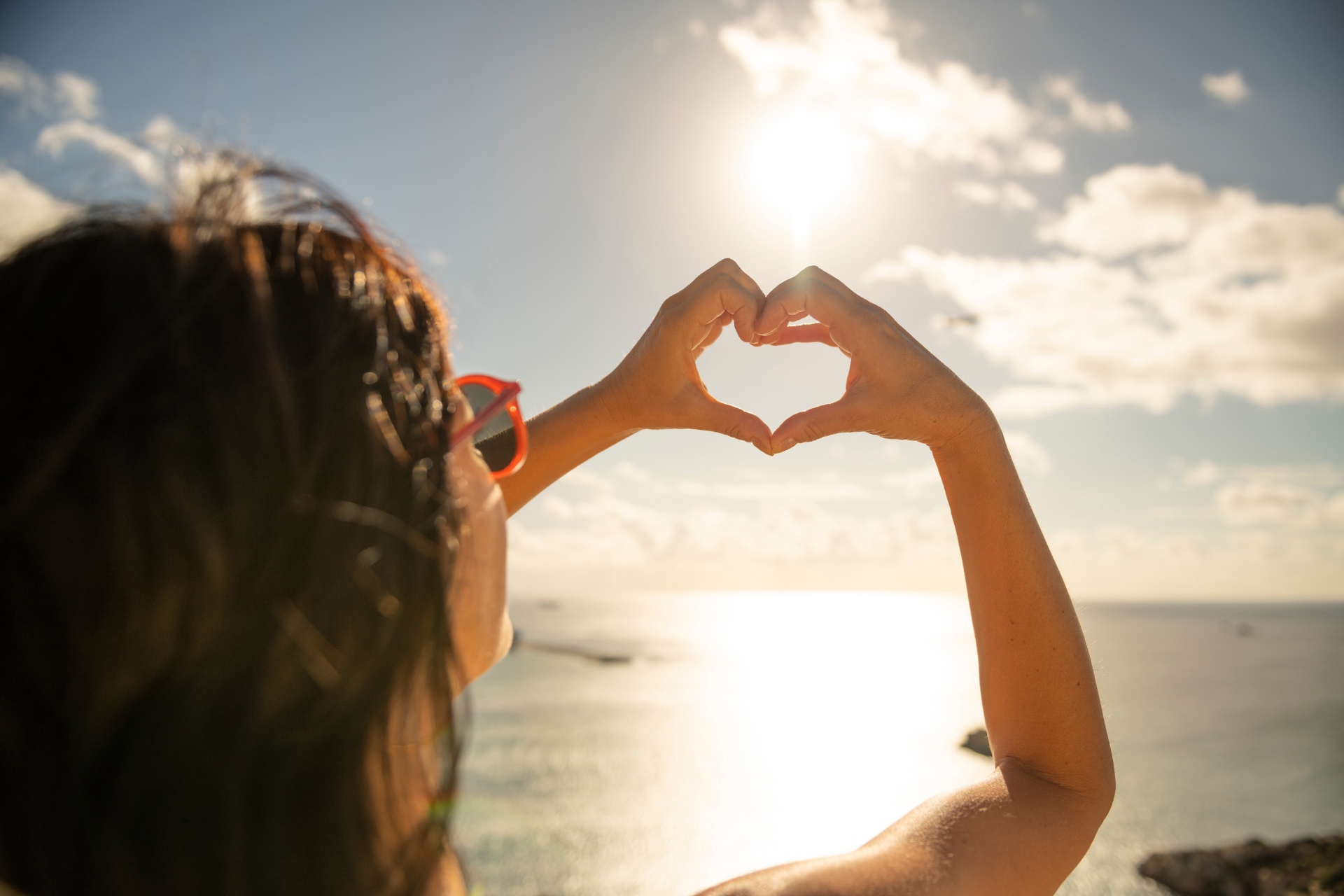 woman holding up a heart sign with her hands
