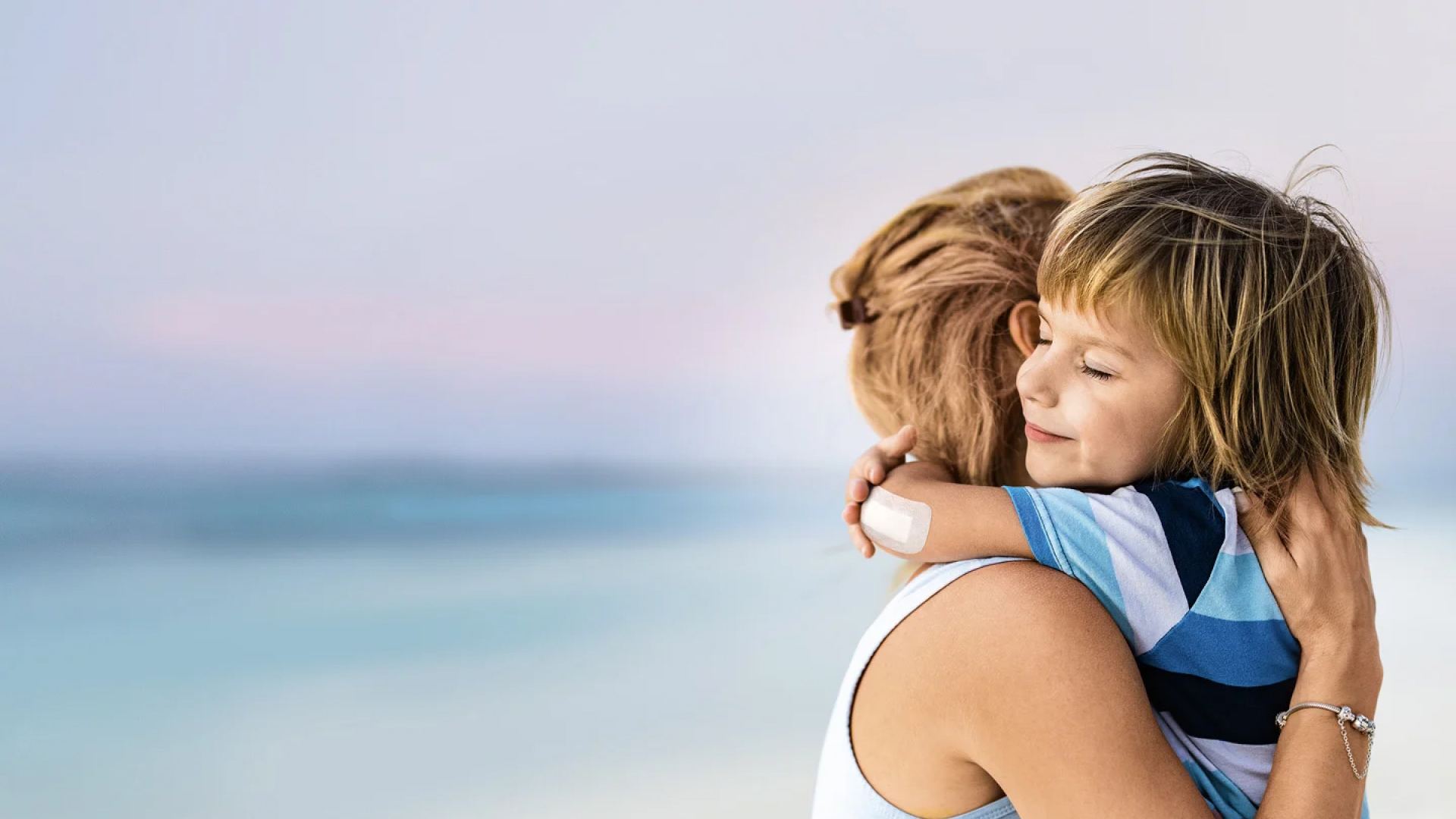 Mother hugging her child in a beach