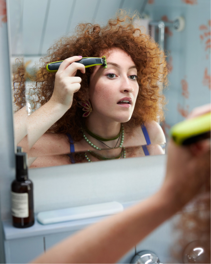 woman using the Philips one blade on her eye brows