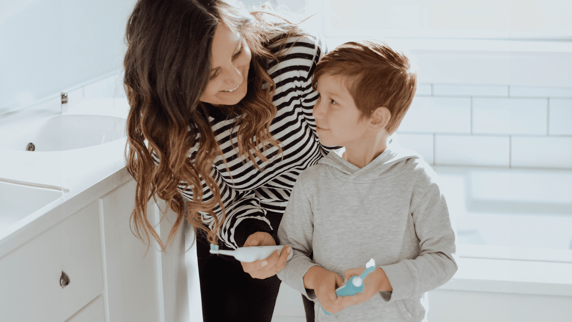 Mother and kid using Sonicare toothbrush