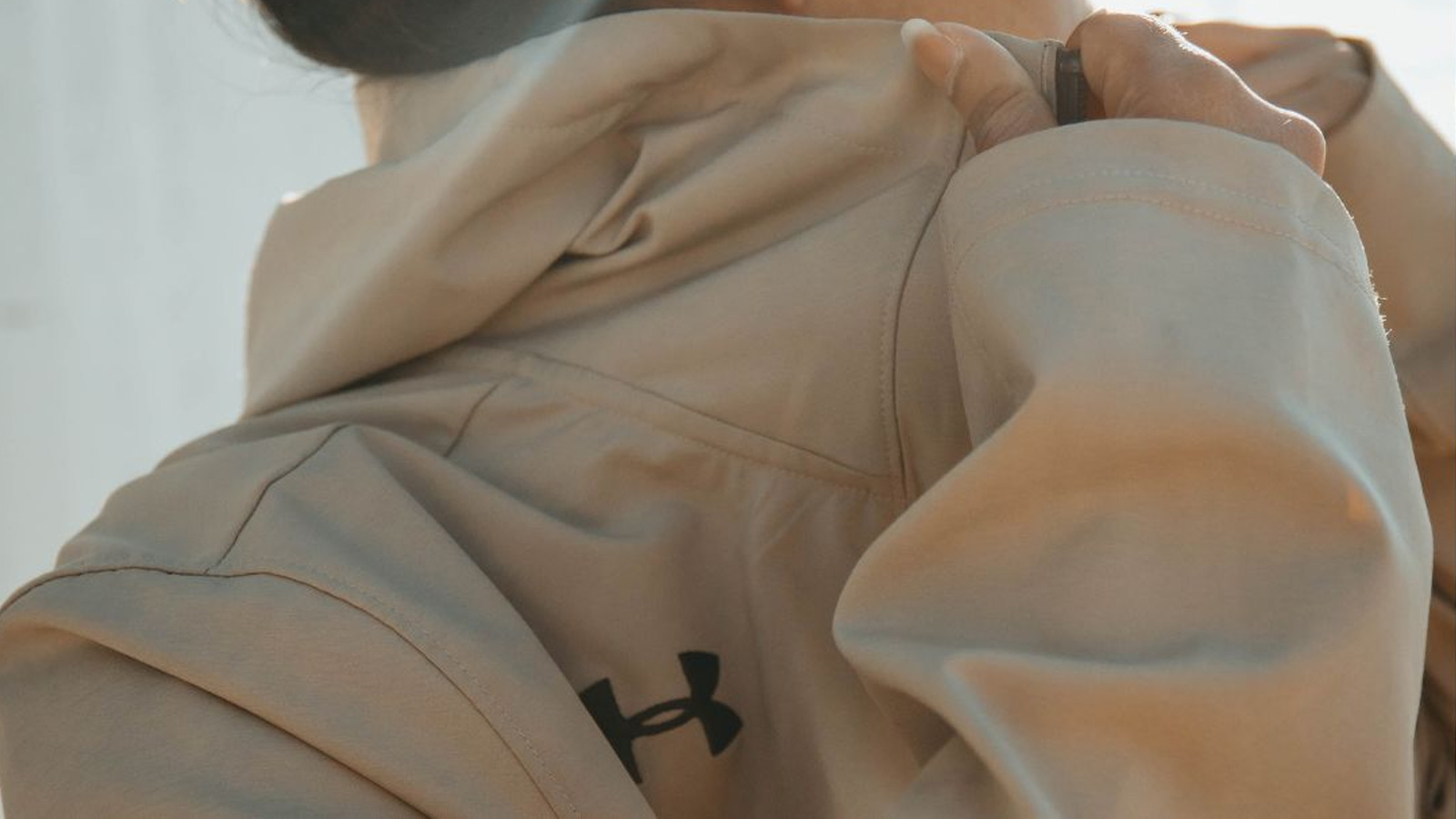 Close up of an Under Armour logo on a beige sports jacket.