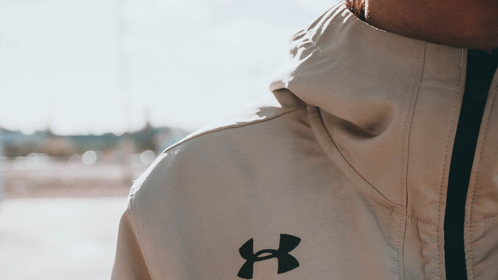 Close up of an Under Armour logo on a beige sports jacket.