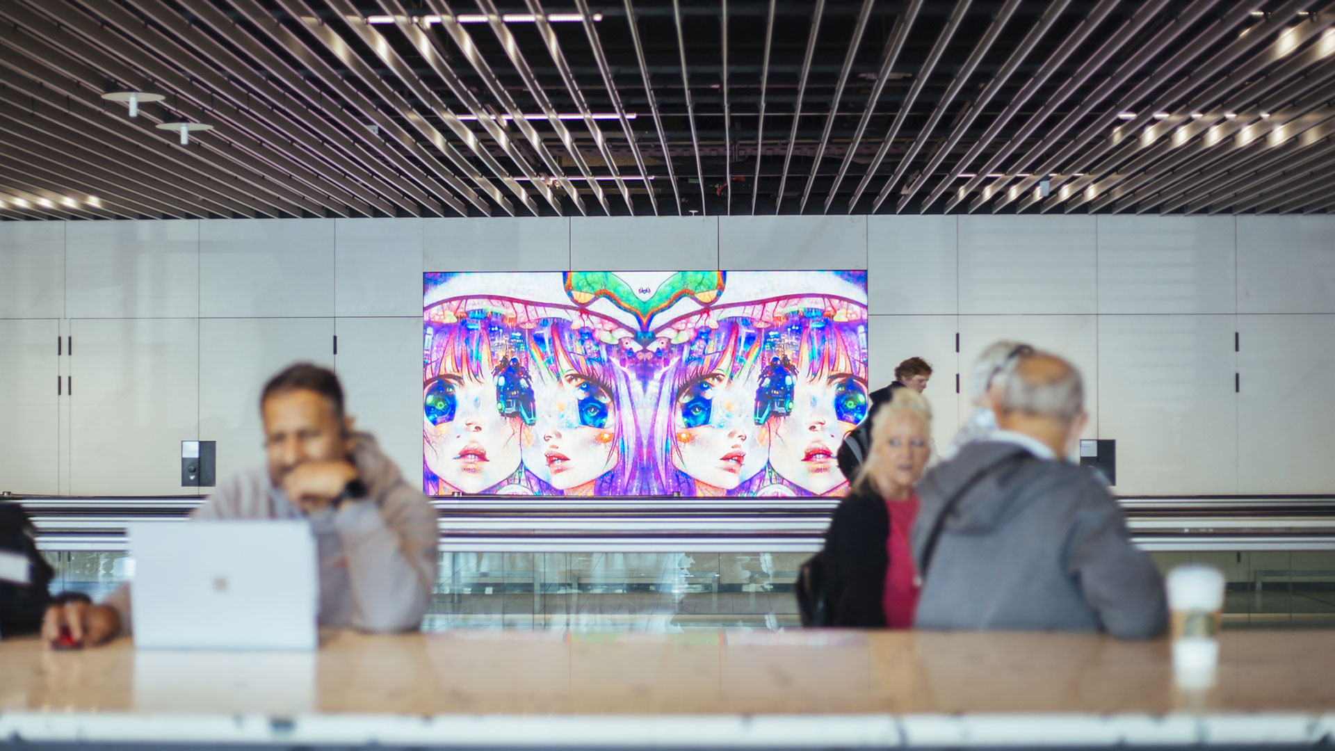 A screen showing an anime-style illustration of four girl's faces.