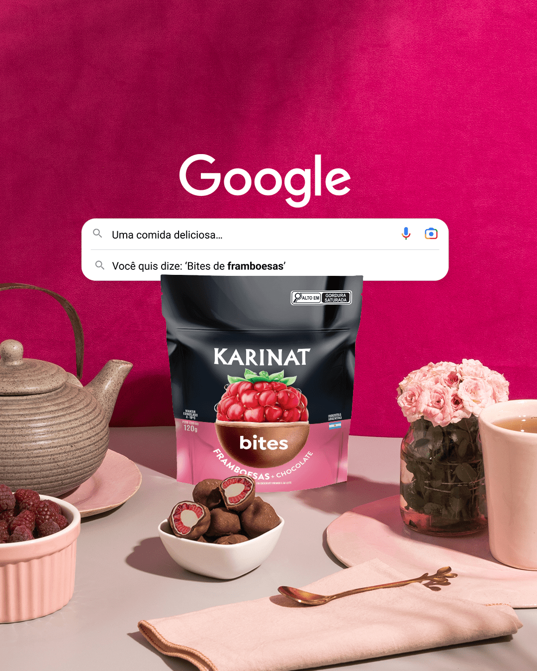 A Karinat Raspberry Bites package on a tea table with a teapot, cup, raspberries, and chocolate bites. Above, a Google search suggests “Raspberry Bites” on a fuchsia background.